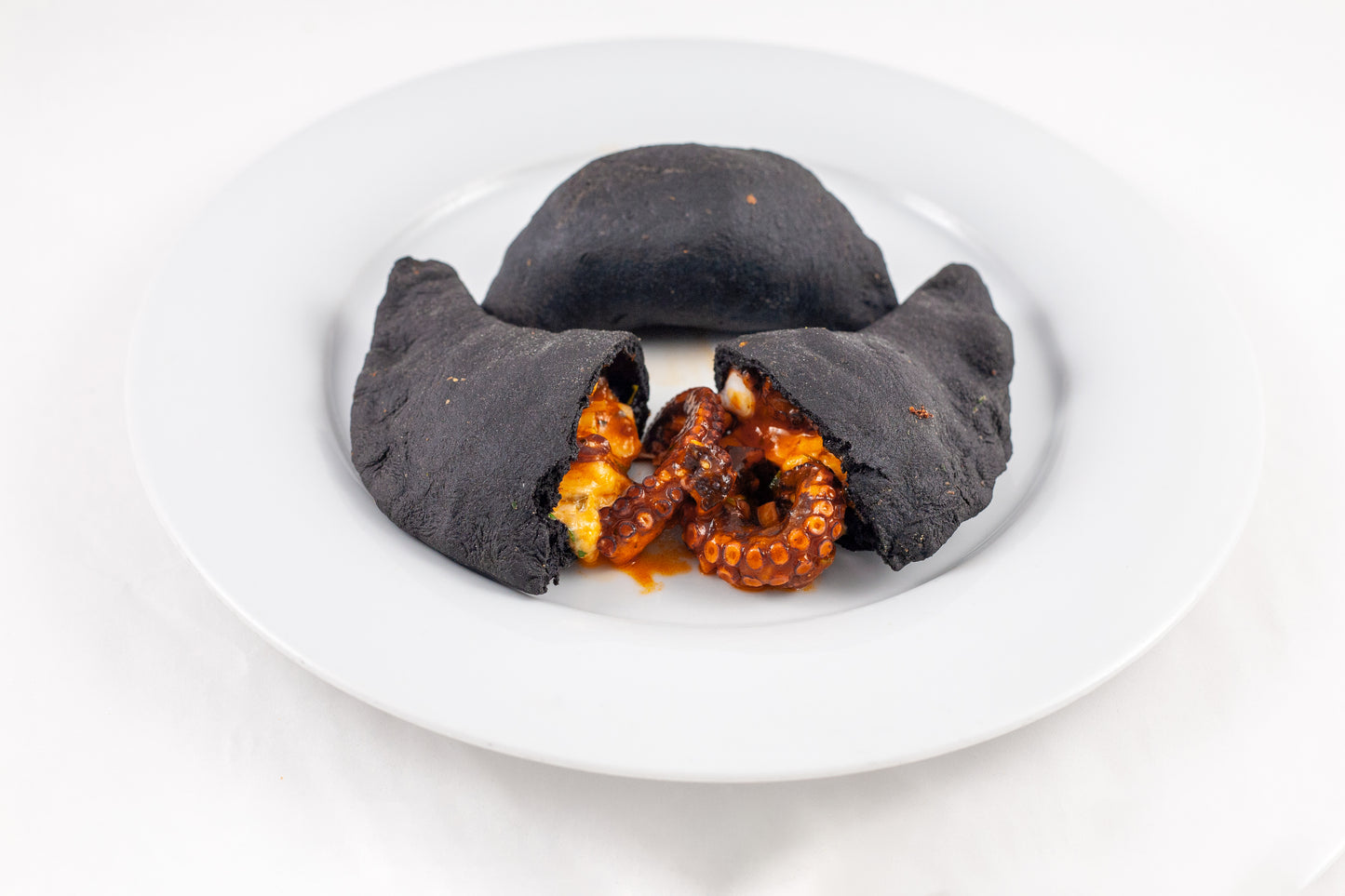 Panzerotto al Nero di Seppia con Ragù di Polpo e Cipolline Stufate